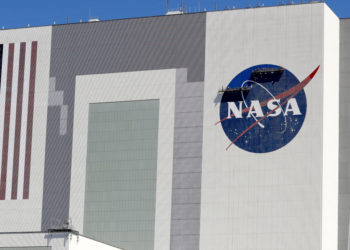 Workers near the top of the 526 ft. Vehicle Assembly Building at the Kennedy Space Center spruce up the NASA logo standing on scaffolds in Cape Canaveral, Fla., Wednesday, May 20, 2020. A SpaceX Falcon 9 rocket scheduled for May 27 will launch a Crew Dragon spacecraft on its first test flight with astronauts on-board to the International Space Station. (AP Photo/John Raoux)