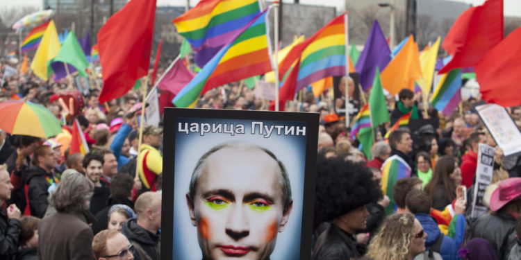 A demonstrator holds up a picture depicting Russian President Vladimir Putin with make-up during a protest by the gay community in Amsterdam in this April 8, 2013 file photo. Putin and his wife, Lyudmila, said on state television on Thursday that they had separated and their marriage was over after 30 years. REUTERS/Cris Toala Olivares/Files (NETHERLANDS - Tags: CIVIL UNREST SOCIETY POLITICS)