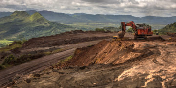 An excavator moves earth to a dump truck at a mining site of Venezuelan iron ore producer CVG Ferrominera Orinoco, on Bolivar Hill outside of Ciudad Piar, Venezuela, on Thursday, July 9, 2015. Photographer: Meridith Kohut/Bloomberg
