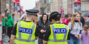 Edinburgh city police keep an eye on crowds at the Royal Mile during Edinburgh Fringe Festival.