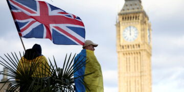 FILE PHOTO: A demonstrator holds a British flag during a protest against Russia's invasion of Ukraine, at Parliament Square in London, Britain, March 6, 2022. REUTERS/Henry Nicholls/File Photo